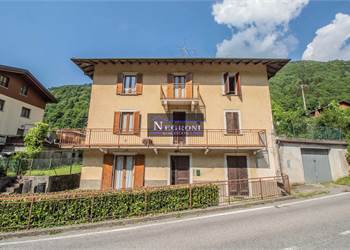 Casa con 5 appartamenti, negozio, autorimessa, terrazzo e giardino a Gandellino!
